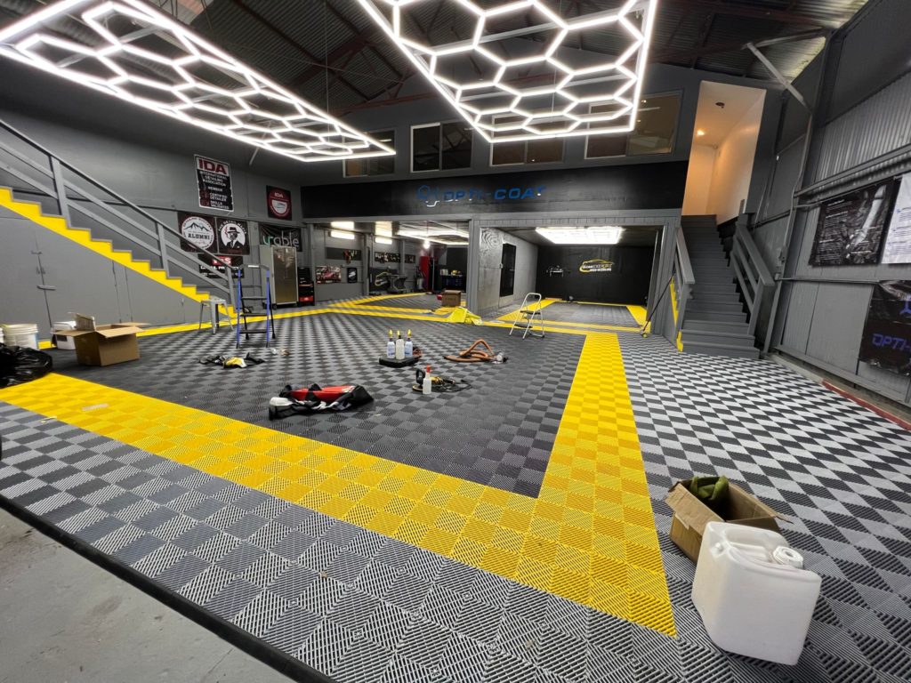 Alternate view of a detailing company with RaceDeck FreeFlow flooring in alloy, yellow, and graphite, a superior alternative to epoxy in Hawaii.