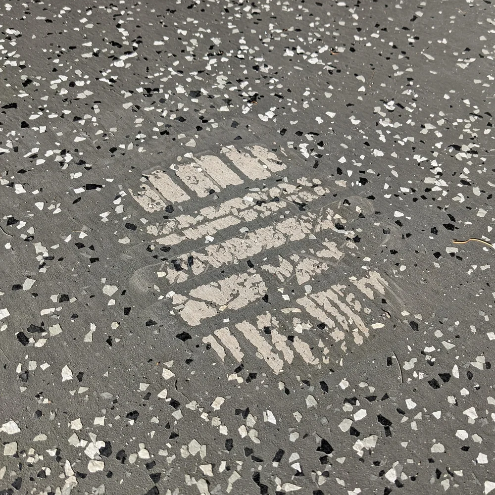 Epoxy flooring damaged by hot tire pickup in a Hawaii garage.